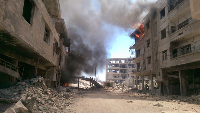 Fire and smoke gush out of buildings following reported air strikes on the Syrian besieged rebel-held town of Darayya, near the capital Damascus, on Tuesday (AFP photo)