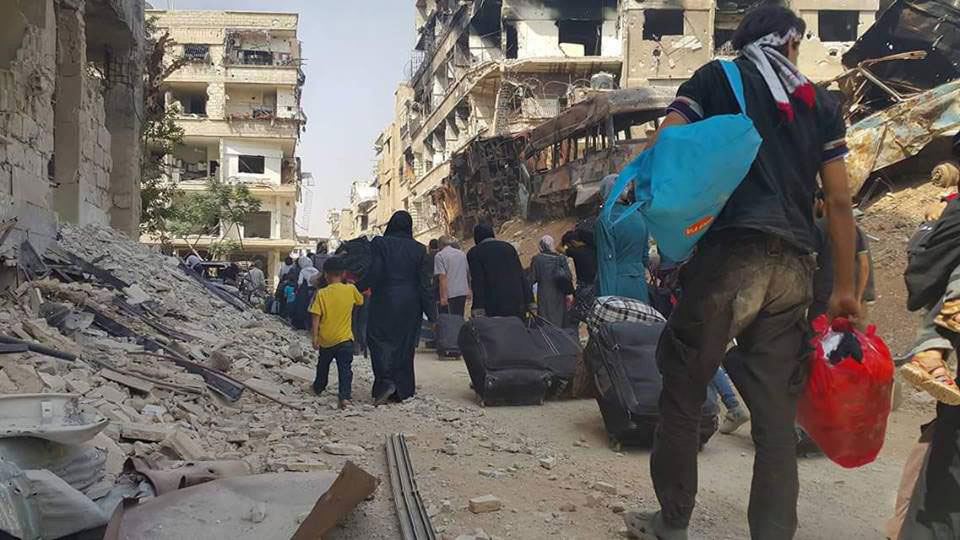 People carry their belongings before being evacuated from the besieged Damascus suburb of Daraya, after an agreement reached on Thursday between rebels and Syria’s army, in this handout picture provided by SANA on Friday (Reuters photo)
