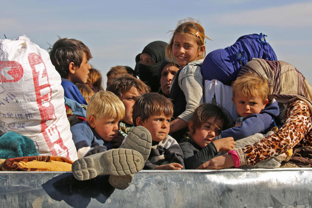 Syrians fleeing areas controlled by militants of the Daesh group are seen on the road as they come to safety in areas held by by Kurdish-Arab Syria Democratic Forces alliance, on Tuesday, near the village of Ein Issa,  some 50 kilometres north of Raqqa, Daesh’s de facto Syrian capital (AFP photo)