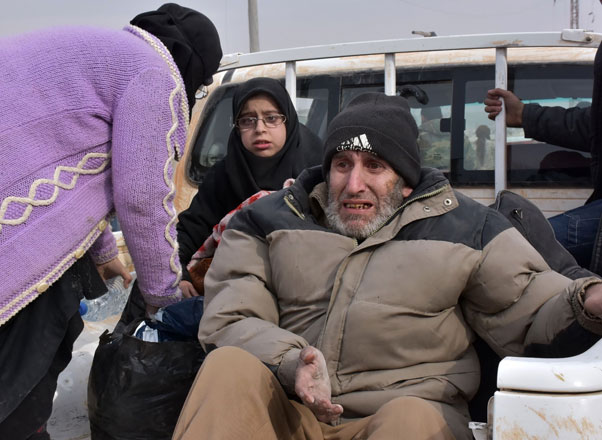 Syrian families, fleeing from various eastern districts of Aleppo, wait to board vehicles on Tuesday in the government-held eastern neighbourhood of Jabal Badro, before heading to government-controlled western Aleppo, as the Syrian government offensive to recapture rebel-held Aleppo has prompted an exodus of civilians (AFP photo)