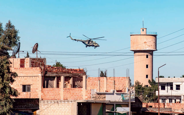 A Russian army helicopter flies over the town of Tal Tamr in the north-eastern Syrian Hasakeh province on the border with Turkey on Sunday (AFP photo)