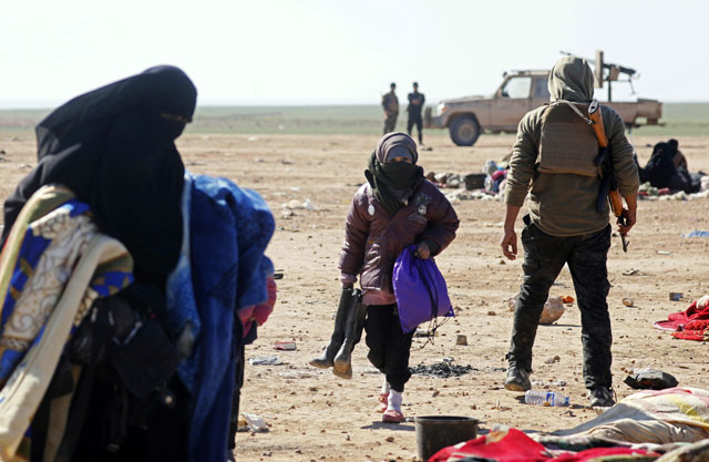 Civilians fleeing fighting between Syrian Democratic Forces (SDF)  and Daesh terrorists in the frontline Syrian village of Baghuz, await to be screened and registered by the SDF in the countryside of the eastern Syrian Deir Ezzor province, on Sunday (AFP photo)