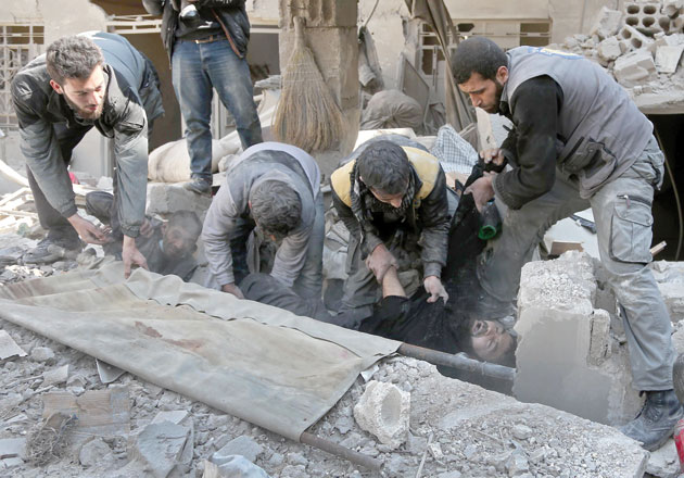 Members of a Syrian civil defence team rescue a man following a reported regime air strike in the rebel-held town of Hammouria, in the besieged Eastern Ghouta region on the outskirts of the capital Damascus, on Wednesday (AFP photo)