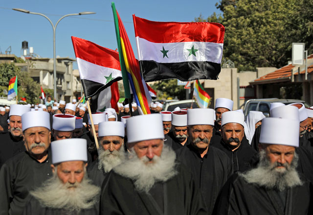 Druze hold Syrian flags during a rally in Buq’ata near the ceasefire line between Israel and Syria in the Israeli-occupied Golan Heights on Thursday (Retures photo)