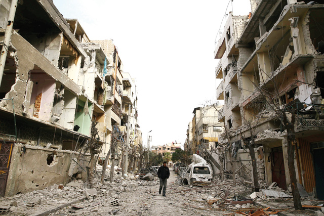 A man walks on a damaged street in the besieged town of Douma, Eastern Ghouta, Damascus, Syria, on Monday (Reuters photo)