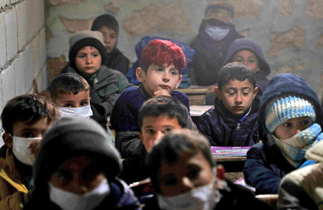Syrian schoolchildren, some wearing masks due to the COVID-19 pandemic, sit at a makeshift school set up by locals in the village of Ma’arin on the outskirts of Azaz in the rebel-controlled northern countryside of Syria’s Aleppo province, on Tuesday  (AFP photo)