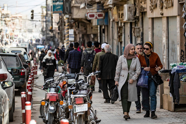 People a shop in a commercial district in Syria's northeastern city of Qamishli on Tuesday (AFP photo)