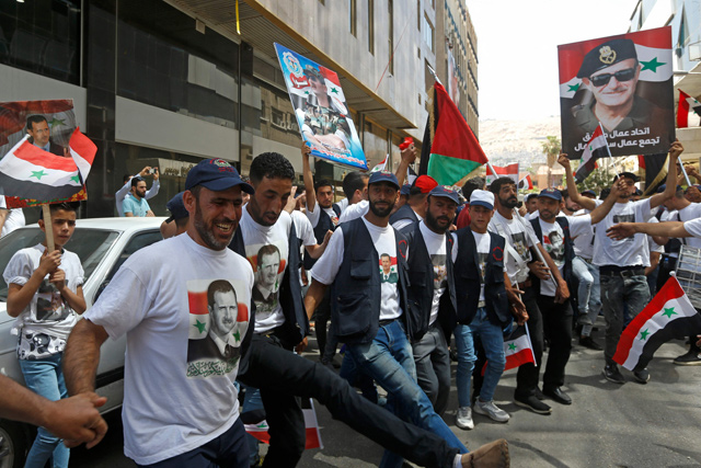 Syrians dance outside a polling station in Damascus, on Wednesday  (AFP photo)