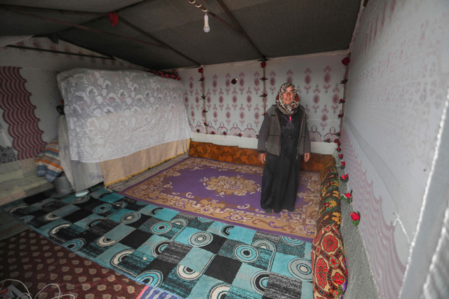 A woman stands in her tent at a make-shift camp for the displaced by the village of Babisqa in Syria’s north-western rebel-held province of Idlib, on Friday  (AFP photo)