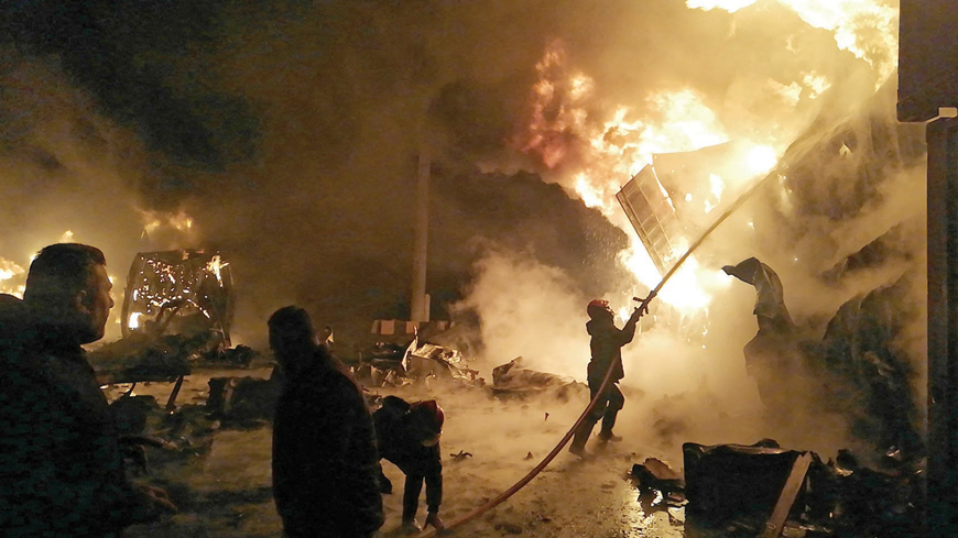 This handout photo released by the official Syrian Arab News Agency shows firefighters battling the blaze at Syria's Latakia port after an Israeli air strike early on Tuesday (AFP photo)