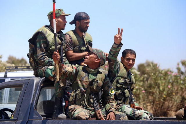 A Syrian soldier gestures as he rides in a car in the town of Quneitra in the Syrian Golan Heights on July 27, 2018 (AFP photo)