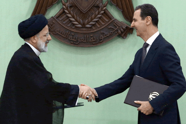 Syria’s President Bashar Assad  and his Iranian counterpart Ebrahim Raisi shake hands after signing a memoranda of understanding on ‘long-term strategic cooperation’ in Damascus on Wednesday (AFP photo)