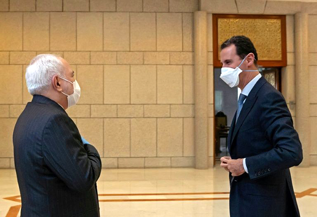 Syrian President Bashar Assad (right) meets with Iranian Foreign Minister Mohammad Javad Zarif, both wearing protective face masks, in the Syrian capital Damascus (AFP photo)