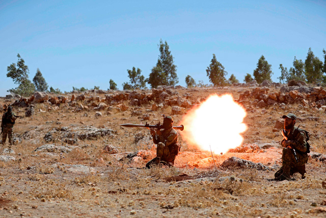 This Syrian fighter fires a rocket-propelled grenade as he attends a mock battle in anticipation of an attack by the regime on Idlib province and the surrounding countryside, during a graduation of new Hayat Tahrir Al Sham members at a camp in the countryside of the northern Idlib province on August 14, 2018 (AFP photo)