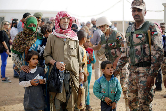 Syrian refugees wait to board a Jordanian army vehicle after crossing into Jordanian territory with their families, in Al Rukban border area, near the northeastern Jordanian border with Syria and Iraq, near the town of Rweished, 240km east of Amman, on September 10, 2015 (Reuters photo)