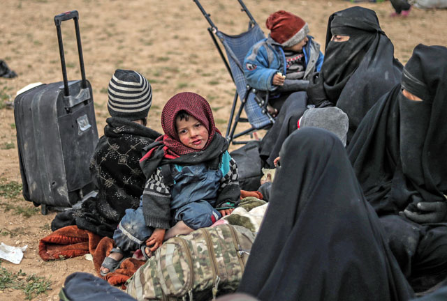 Civilians evacuated from the Daesh group’s embattled holdout of Baghouz wait at a screening area held by the US-backed Syrian Democratic Forces during an operation to expel Daesh terrorists from the area, in the eastern Syrian province of Deir Ezzor, on Tuesday (AFP photo)