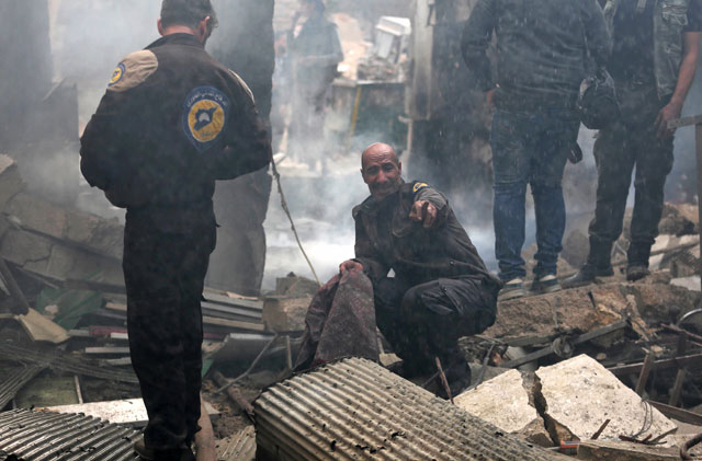 A member of the Syrian civil defence, known as the white helmets, reacts at the site of an air raid on the rebel-held besieged town of Harasta, in the Eastern Ghouta region on the outskirts of Damascus, on Wednesday (AFP photo)