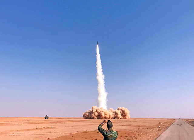 A rocket is fired by Syrian forces from the village of Suway'iah, near the Syrian border town of Albu Kamal, on Friday (AFP photo)