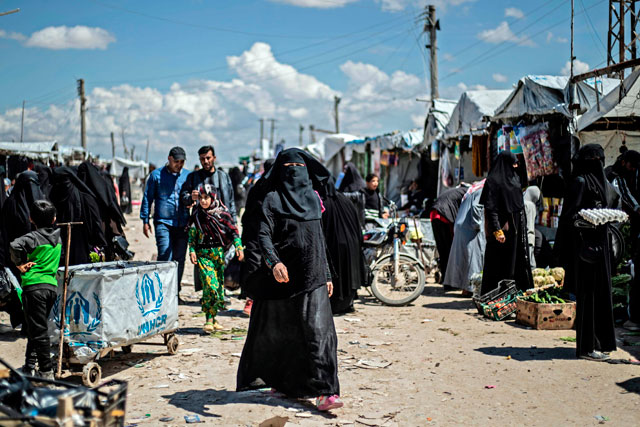 Women displaced from Syria’s eastern Deir Ezzor province walk in a market inside Al Hol camp for displaced people, in  Al Hasakeh governorate in north-eastern Syria, on Thursday (AFP photo)