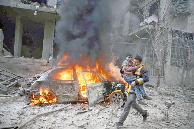 A Syria Civil Defence member carries a wounded child in the besieged town of Hamoria, Eastern Ghouta, in Damascus, Syria, on Saturday (Reuters photo)
