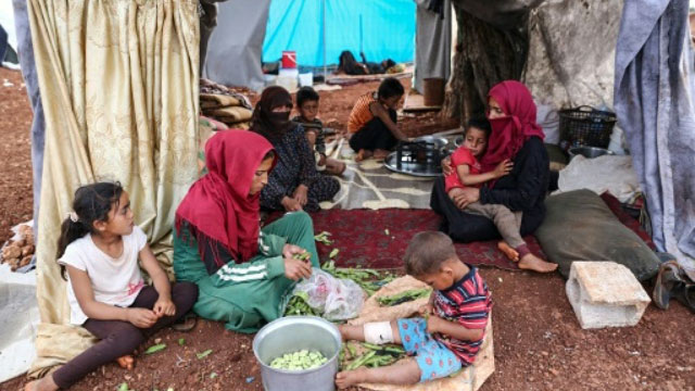Displaced Syrian women prepare food at a makeshift camp in the extremist-held province of Idlib on Thursday (AFP photo)