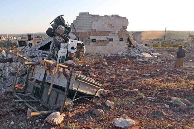 In this file photo taken on May 20, a man gazes at rubble and damaged vehicles in the town of Kafranbel in the rebel-held part of the Syrian Idlib province (AFP photo)