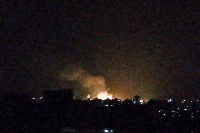 An image grab taken from an AFP video shows what appears to be smoke billowing over buildings near the Syrian capital Damascus, following a reported Israeli air strike overnight, on Monday (AFP photo)