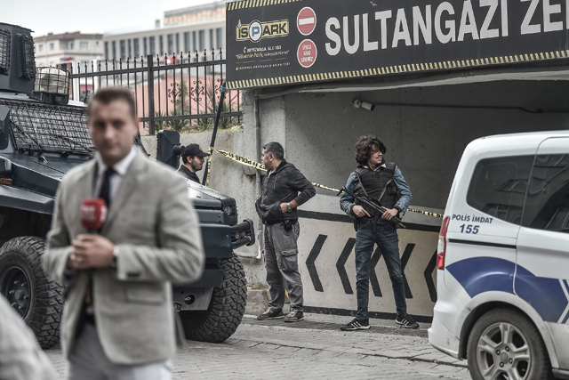 A journalist reports as Turkish police stand guard at the entrance of the cordoned off underground car park, in the Sultan Gazi district of Istanbul, on Tuesday, after Turkish police found an abandoned car belonging to the Saudi consulate, three weeks after the murder of journalist Jamal Khashoggi in the Saudi consulate (AFP photo)