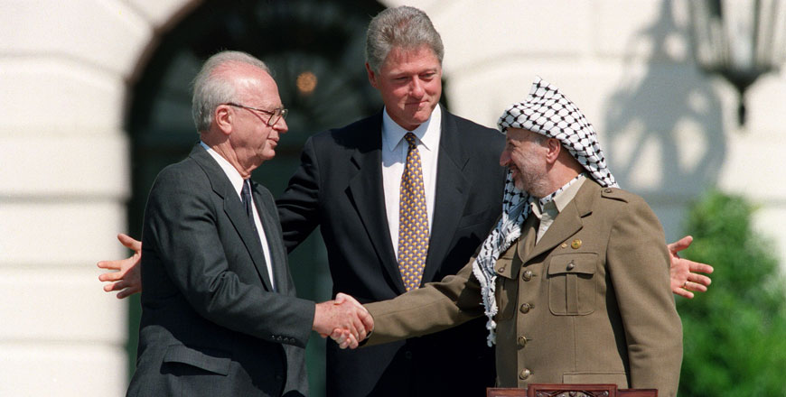 In this file photo taken on September 13, 1993, US president Bill Clinton (centre) stands between PLO leader Yasser Arafat (right) and Israeli prime minister Yitzahk Rabin (left) as they shake hands for the first time, at the White House in Washington DC, after signing the historic Israel-PLO Oslo Accords on Palestinian autonomy in the occupied territories (AFP photo)