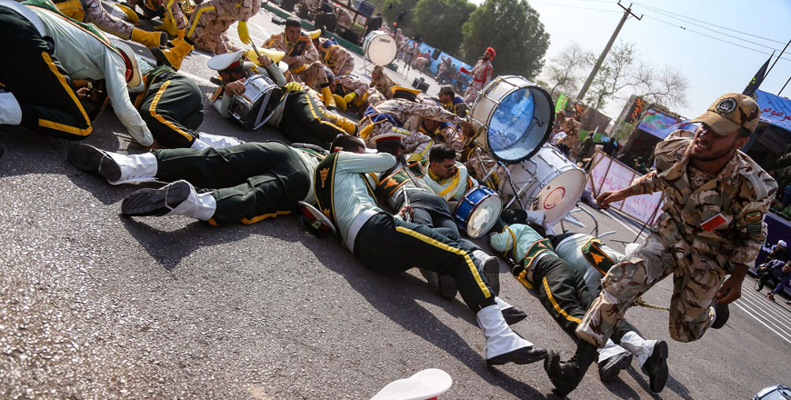 A soldier running past injured comrades lying on the ground at the scene of an attack on a military parade in the south-western Iranian city of Ahvaz on Saturday (AFP photo)
