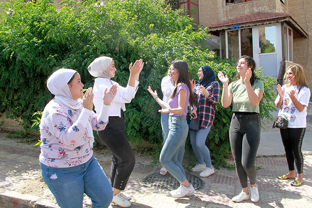 Students are seen celebrating after the announcement of the 2021 General Secondary Education Certificate Examination (Tawjihi) on Monday (Photo by Abdullah Ayoub)