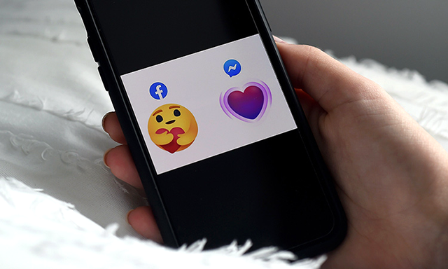 The two new ‘care’ emojis in Facebook and Messenger are displayed on the screen (AFP photo)