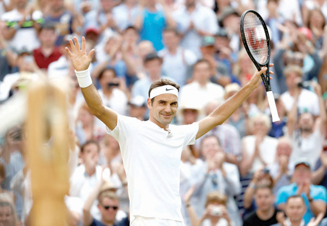 Switzerland's Roger Federer celebrates winning the fourth round match against Bulgaria's Grigor Dimitrov at the All England Lawn Tennis Club in Wimbledon, southwest London, on Monday (Reuters photo by Stefan Wermuth)