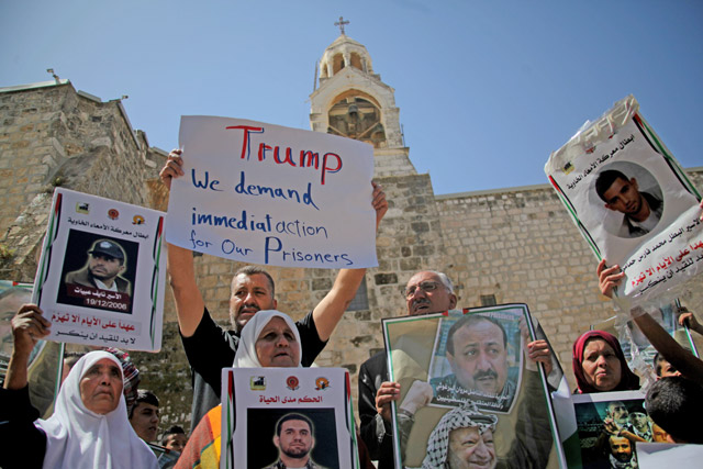 Palestinian demonstrators hold banners and posters during a demonstration in support of the Palestinian prisoners held in Israeli jails, outside the Mahd Church as US President Donald Trump meets Palestinian President Mahmoud Abbas in Bethlehem, West Bank, on Tuesday (Anadolu Agency photo)