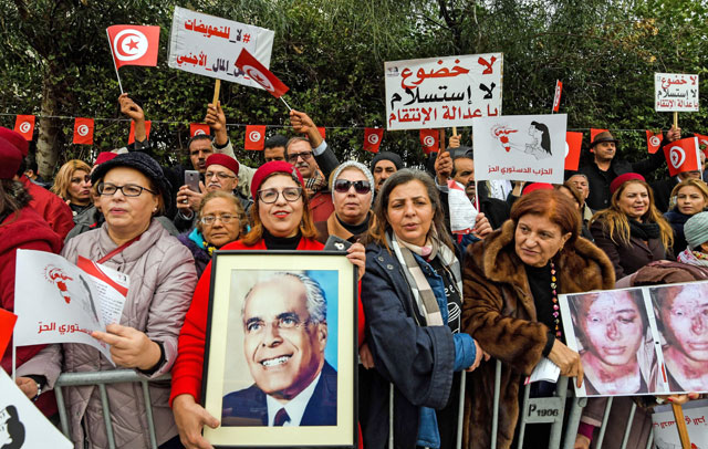 Members of Tunisia's Free Destourian Party (Free Constitutional Party) shout slogans and hold up protest signs and portraits of late president Habib Bourguiba as they demonstrate against the Truth and Dignity Commission outside its closing conference in the capital Tunis, on Friday (AFP photo)