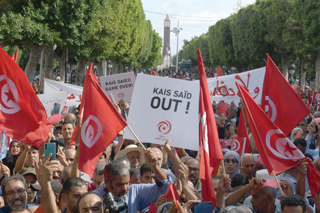 Supporters of the Tunisian Free Destourian Party wave national flags and raise placards during a demonstration against President Kais Saied in the capital Tunis, on Saturday (AFP photo)