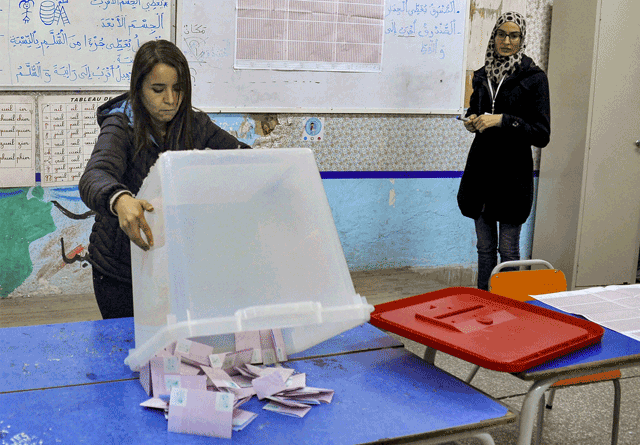 An ISIE agent begins counting ballots at a polling station in Tunis on Saturday during the parliamentary election (AFP photo)