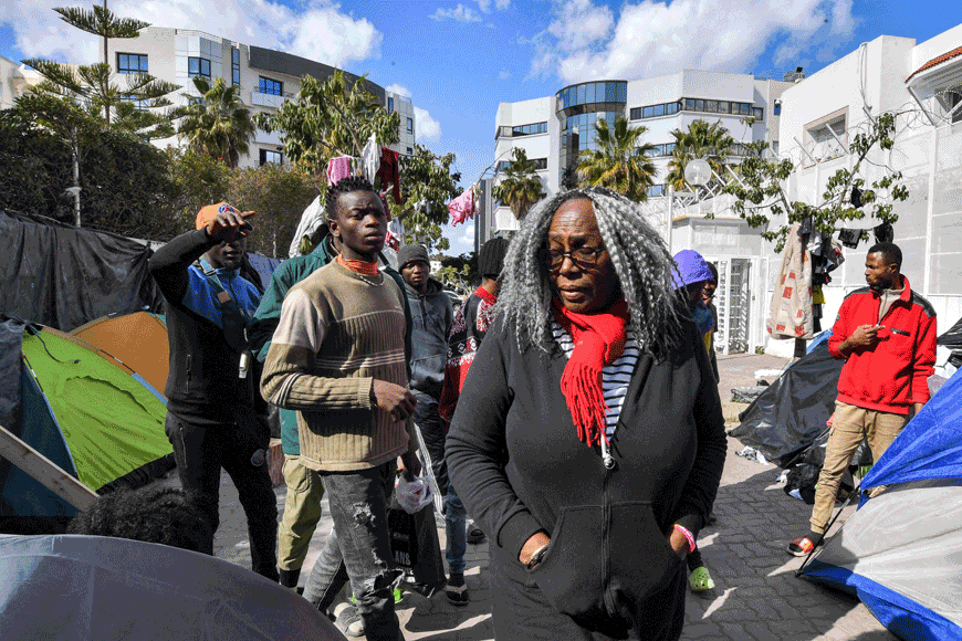 Saadia Mosbah (centre), a Tunisian woman who heads the anti-racism campaign group Mnemty, visits a camp housing Sub-Saharan African migrants pitched outside the headquarters of the International Organisation for Migration in Tunis, on Tuesday (AFP photo)