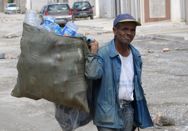 A man collects recyclable items in the Tunis district of Ettadhamen on Tuesday, ahead of the September 15 presidential election (AFP photo)