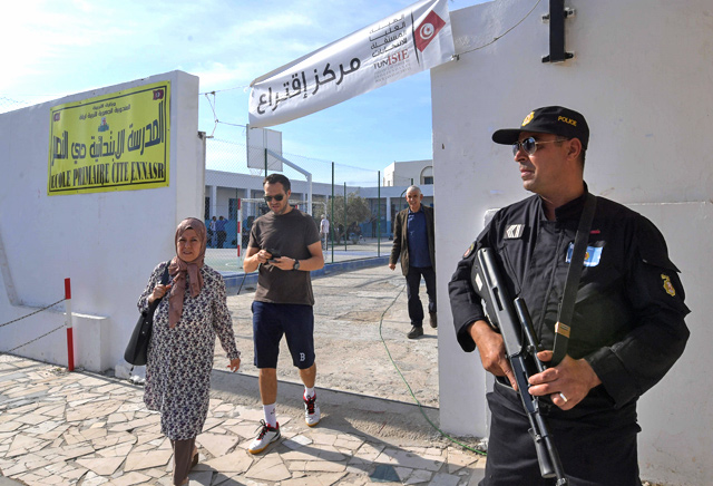 A Tunisian policeman stands guard outside a polling station in the capital Tunis on Sunday during the second round of the presidential election (AFP photo)