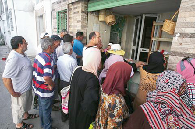 People queue in front of a bakery selling subsidised bread in Tunis’ Halfaouine district, on Saturday (AFP photo)