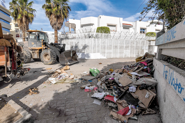 A bulldozer clears debris outside the International Organisation for Migration (IOM) headquarters in Tunis on Friday (AFP photo)