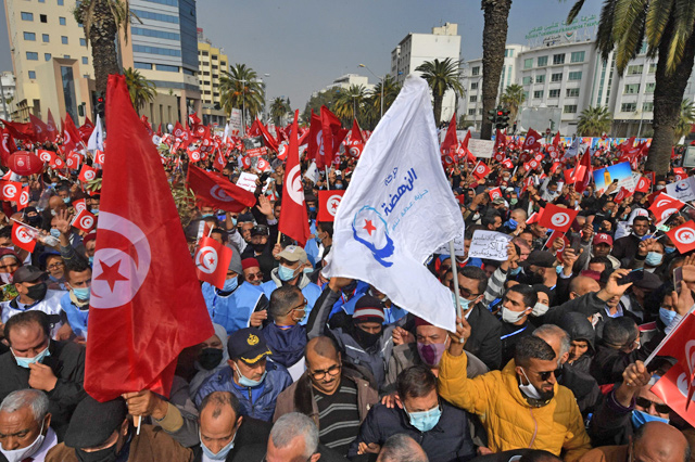 Supporters of the Islamist Ennahdha Party wave national and party during a demonstration in support of the Tunisian government on Saturday in the capital Tunis  (AFP photo)