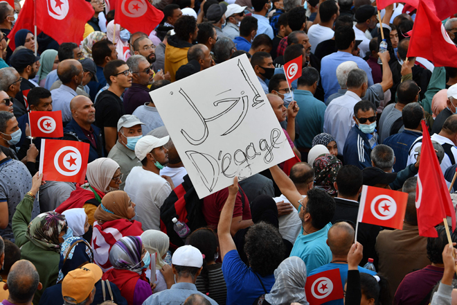Tunisians raise national flags during a rally against their president along the Habib Bourguiba avenue in the capital Tunis on Sunday (AFP photo)