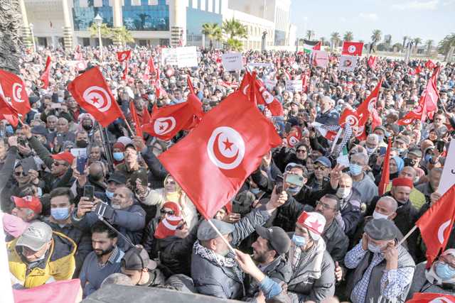 Protesters wave Tunisian national flags during a demonstration called for by Tunisia's Islamist-inspired Ennahdha Party against President Kais Saied's recent decrees, outside the Tunis Opera House in the centre of the capital Tunis, on Sunday (AFP photo)
