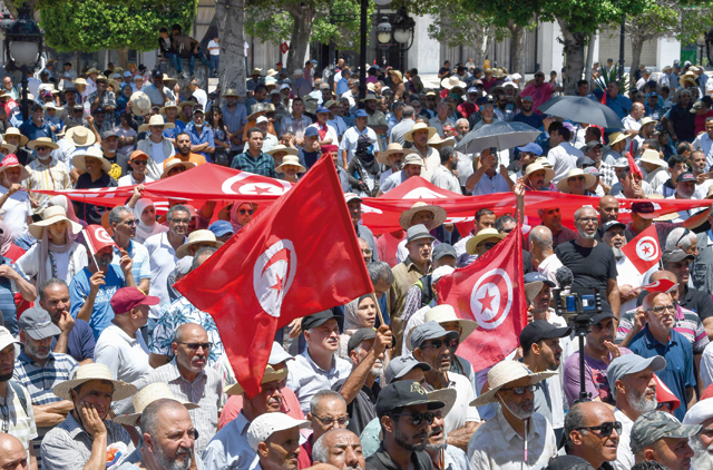 Tunisian protesters lift national flags during a demonstration in the capital Tunis on Sunday, against President Kais Saied and the upcoming July 25 constitutional referendum  (AFP photo)