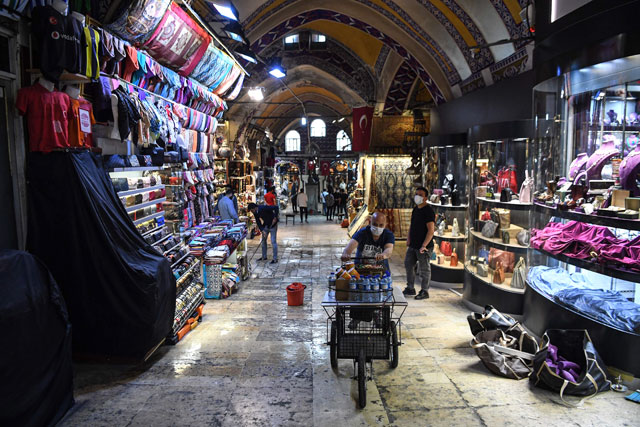 Shop owners wearing protective face masks open their shops in the iconic Grand Bazaar following their closure due to the coronavirus pandemic in Istanbul, on Monday (AFP photo)