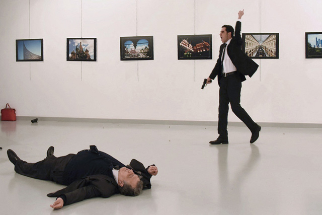 This file photo taken on December 19, 2016, shows Andrei Karlov, the Russian ambassador to Ankara, lying on the floor after being shot by Mevlut Mert Altintas(right) in an attack during a public event in Ankara (AFP photo)