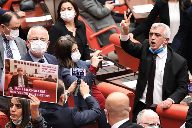   Turkish member of parliament for the left-wing political party Peoples’ Democratic Party Omer Faruk Gergerlioglu (centre) reacts as he is surrounded by MPs applauding and brandishing postcards after he was dismissed following a vote at the Turkish parliament in Ankara, on Wednesday (AFP photo)