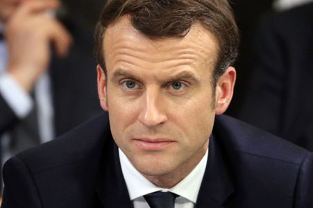 French president Emmanuel Macron (centre) takes part in a meeting in Evry-Courcouronnes, on Monday (AFP photo)